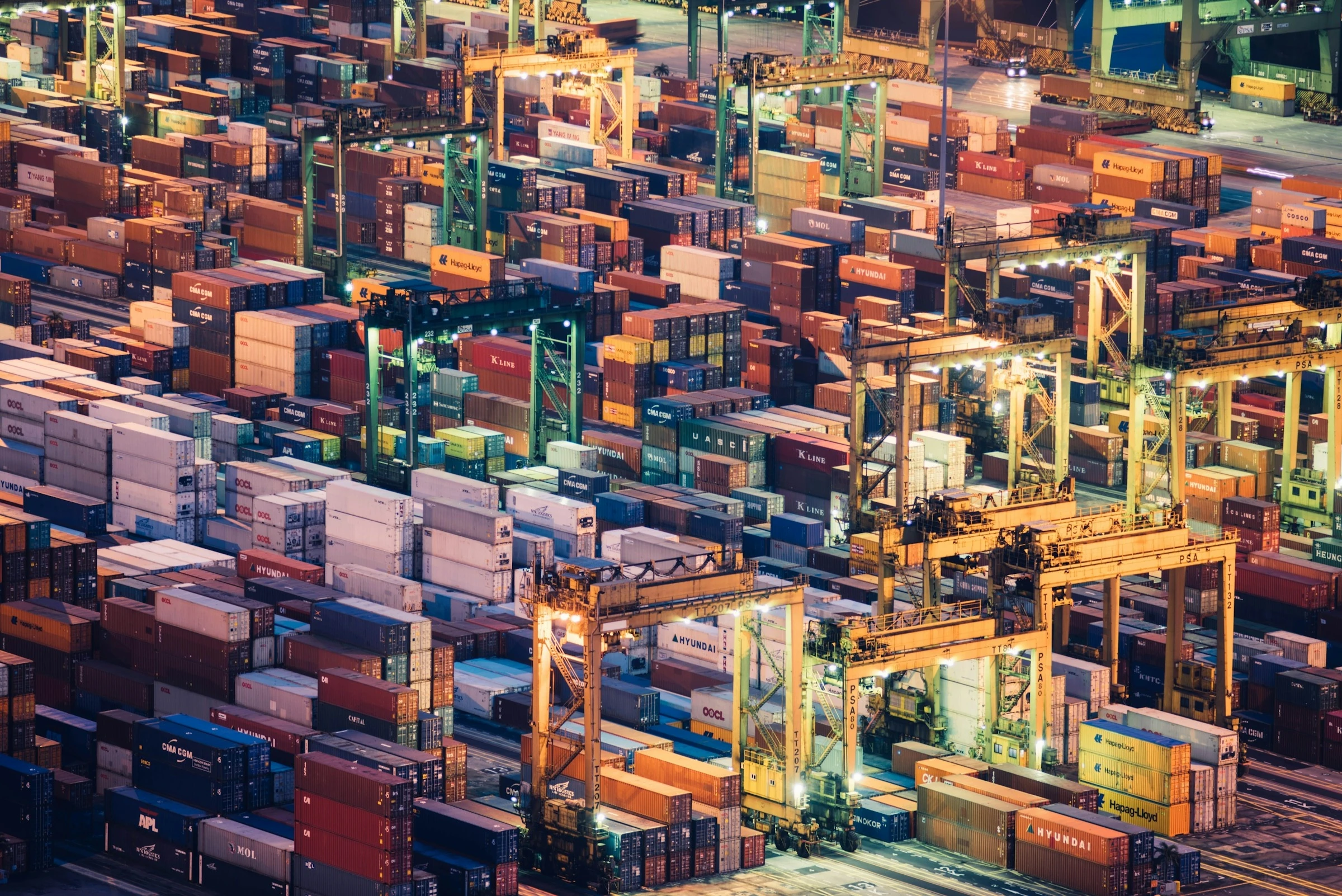 Aerial view of a container terminal with illuminated gantry cranes